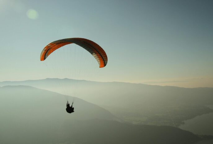 Experience the thrill of paragliding over the stunning Lake Annecy with breathtaking mountain views.